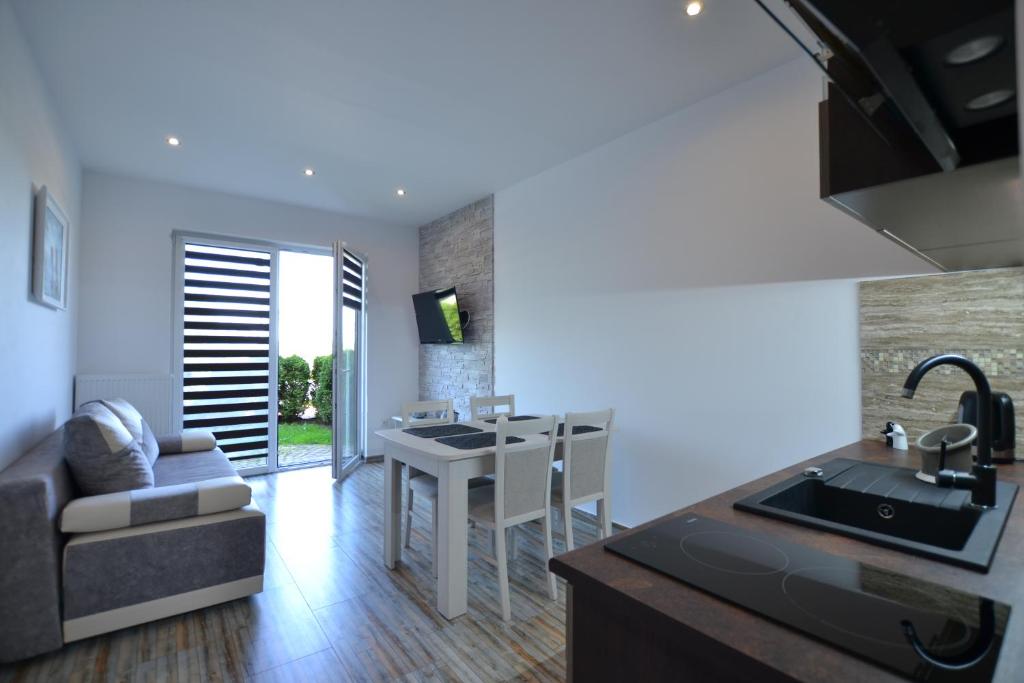 a kitchen and living room with a sink and a table at Darłówko Apartament Morski III in Darłówko