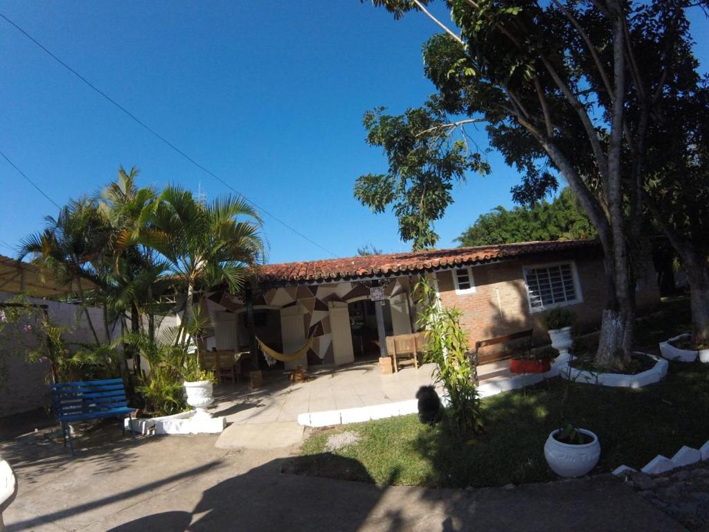 a house with palm trees and a blue bench at Pousada Doce Lar in Itatiba