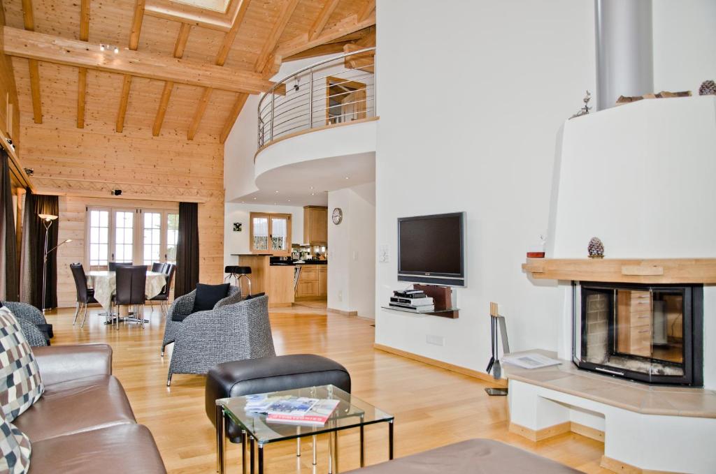 ein Wohnzimmer mit Möbeln und einem Kamin in der Unterkunft Chalet Rivendell - GRIWA RENT AG in Grindelwald