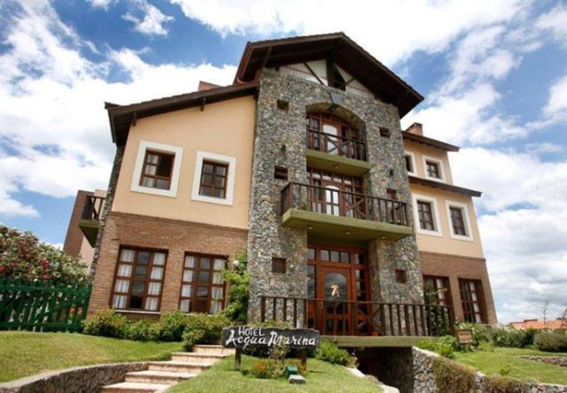 un grand bâtiment avec une enseigne devant dans l'établissement Acquamarina Hotel, à Villa Gesell