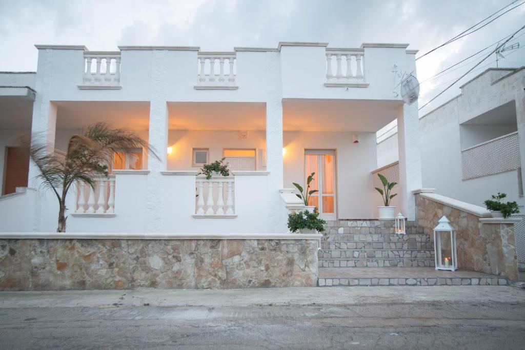 una casa bianca con le scale di fronte di CORTE DELL'IMMACOLATA AL MARE a Marina di Mancaversa