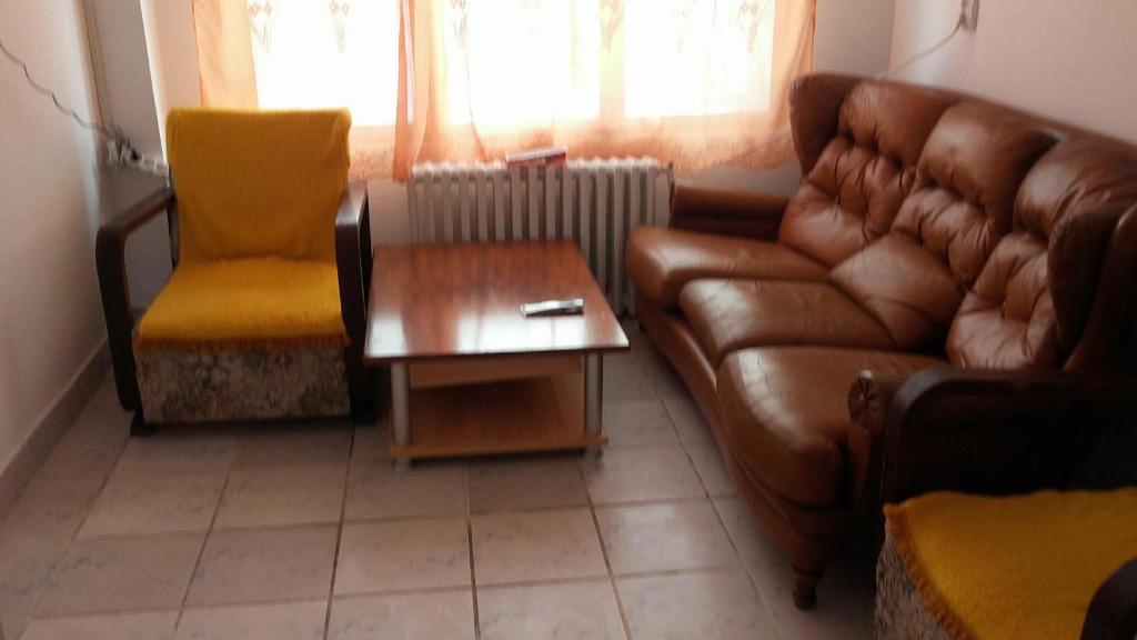 ein Wohnzimmer mit einem Sofa und einem Tisch in der Unterkunft Casa albastră in Marghita