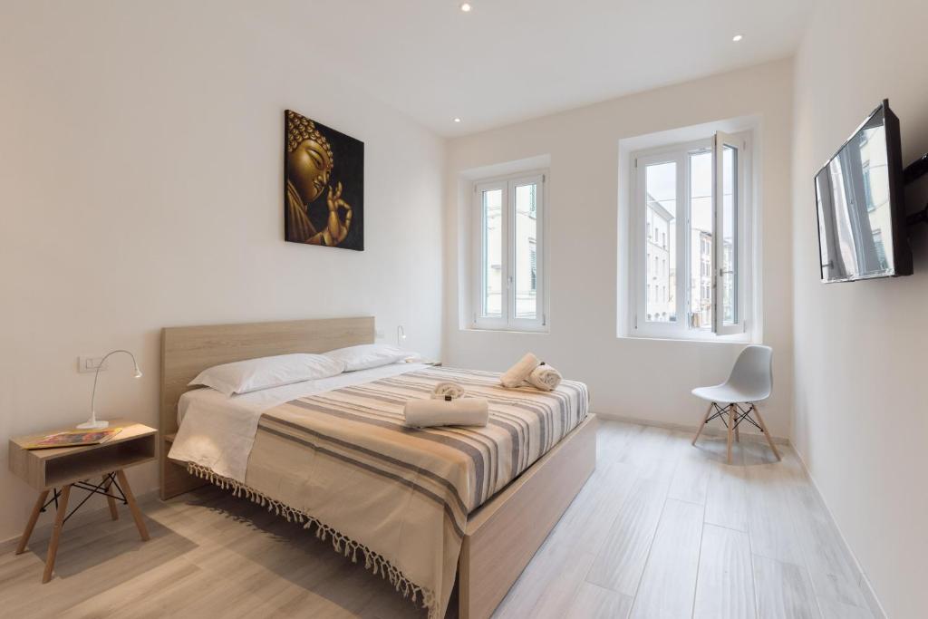 a white bedroom with a bed and two windows at Masai - One bedroom flat 1st floor by train station in Florence