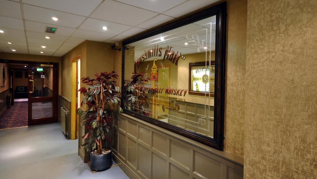 a restaurant with a window and a potted plant at Royal Court Hotel in Portrush
