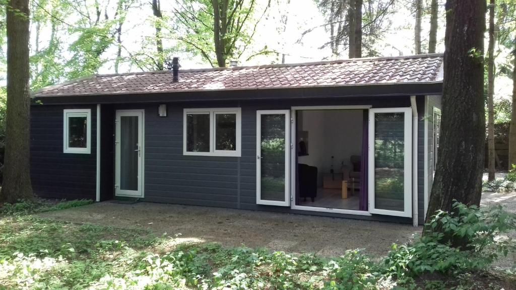 ein winziges Haus mit einer großen Schiebetür in der Unterkunft t'Bakkersboschje nummer 11 in Putten