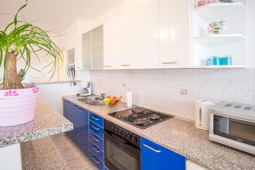 a kitchen with blue cabinets and a sink at Apartments Stasic in Vrbnik