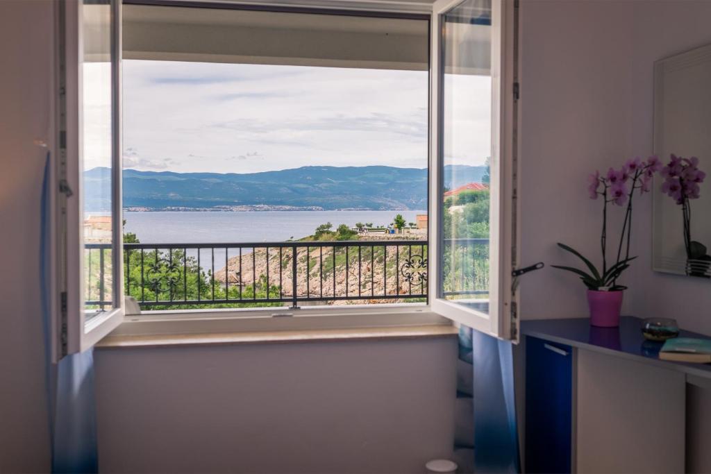 a window with a view of the water at Apartments Stasic in Vrbnik