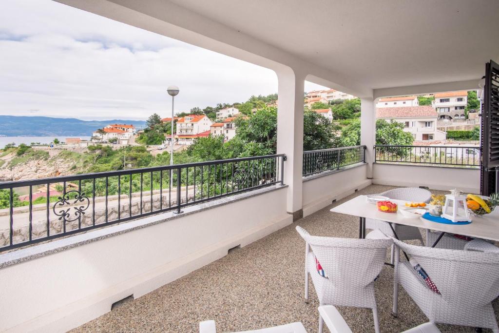 a balcony with a table and chairs and a view at Apartments Stasic in Vrbnik