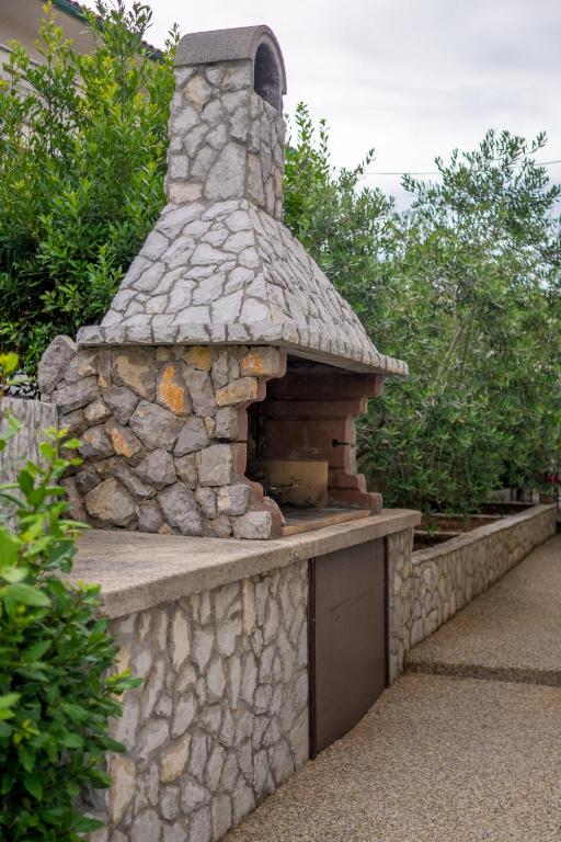 an outdoor stone oven in a stone wall at Apartments Stasic in Vrbnik