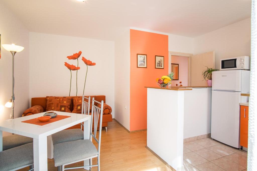 a kitchen and a living room with a table and a refrigerator at Apartments Stasic in Vrbnik