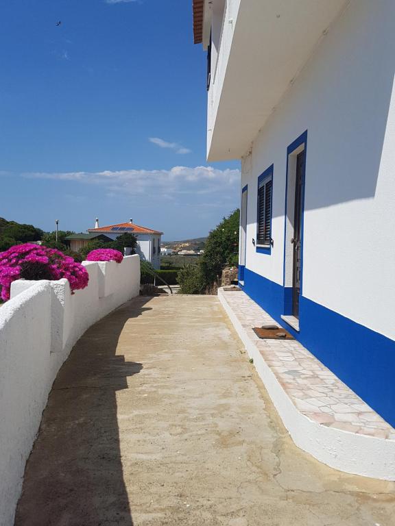 un edificio blanco y azul con flores en el lateral en Casa Barroca, en Carrapateira