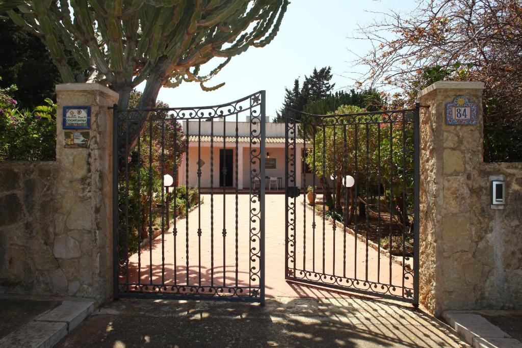 an iron gate with a tree in front of a building at TONNARA84 in San Vito lo Capo