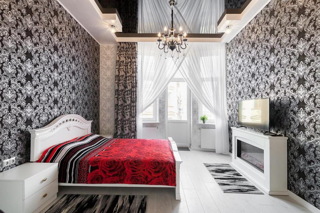 - une chambre avec un lit rouge et une cheminée dans l'établissement Apartment on Dudayeva 17, à Lviv