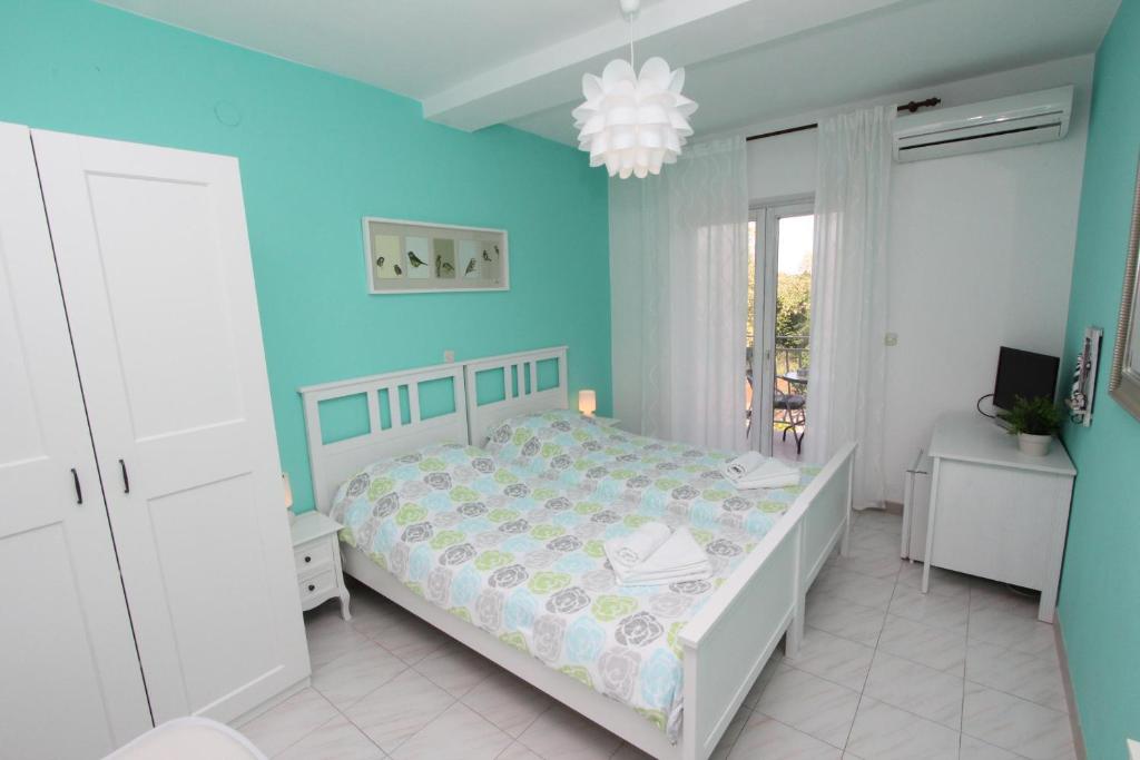 1 dormitorio con cama y pared azul en Guest House Ambienti, en Rovinj