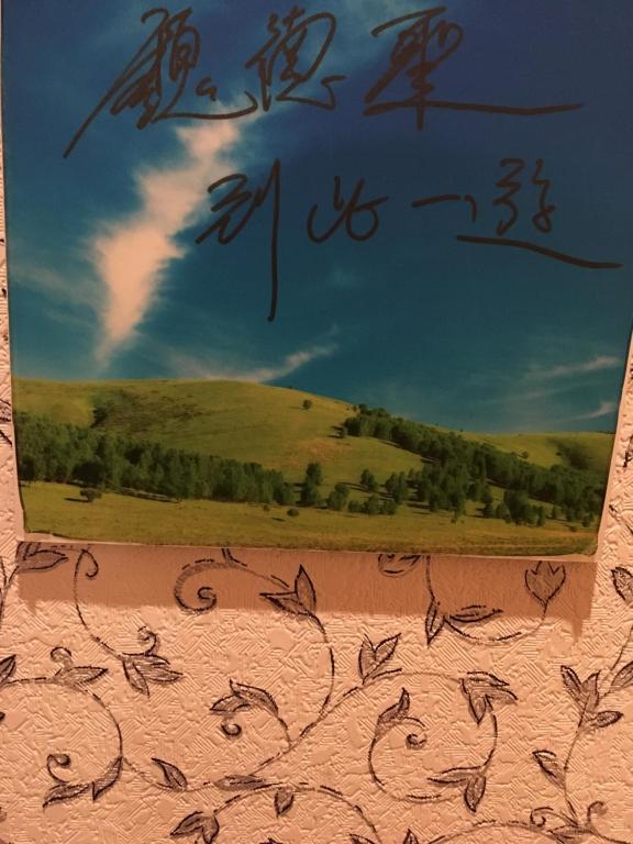a painting of a field and sky with writing on a wall at Yilan Real Fun Homestay in Dongshan