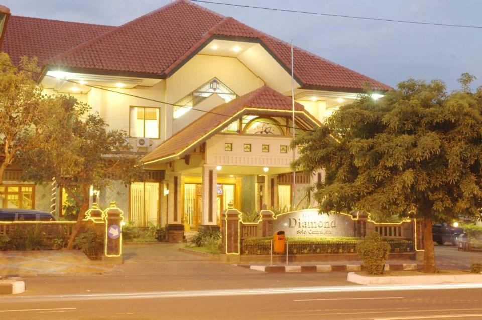 a large yellow house with a sign in front of it at Hotel Diamond in Solo
