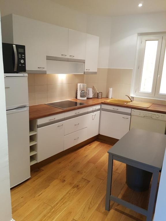 a kitchen with white cabinets and a table in it at le mauritania in Sainte-Maxime