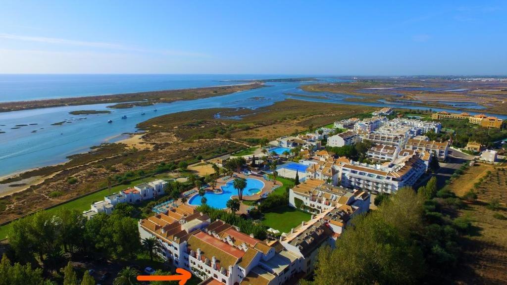 uma vista aérea de um resort ao lado de uma massa de água em Estudio Piscina e Praia, Cabanas de Tavira em Tavira
