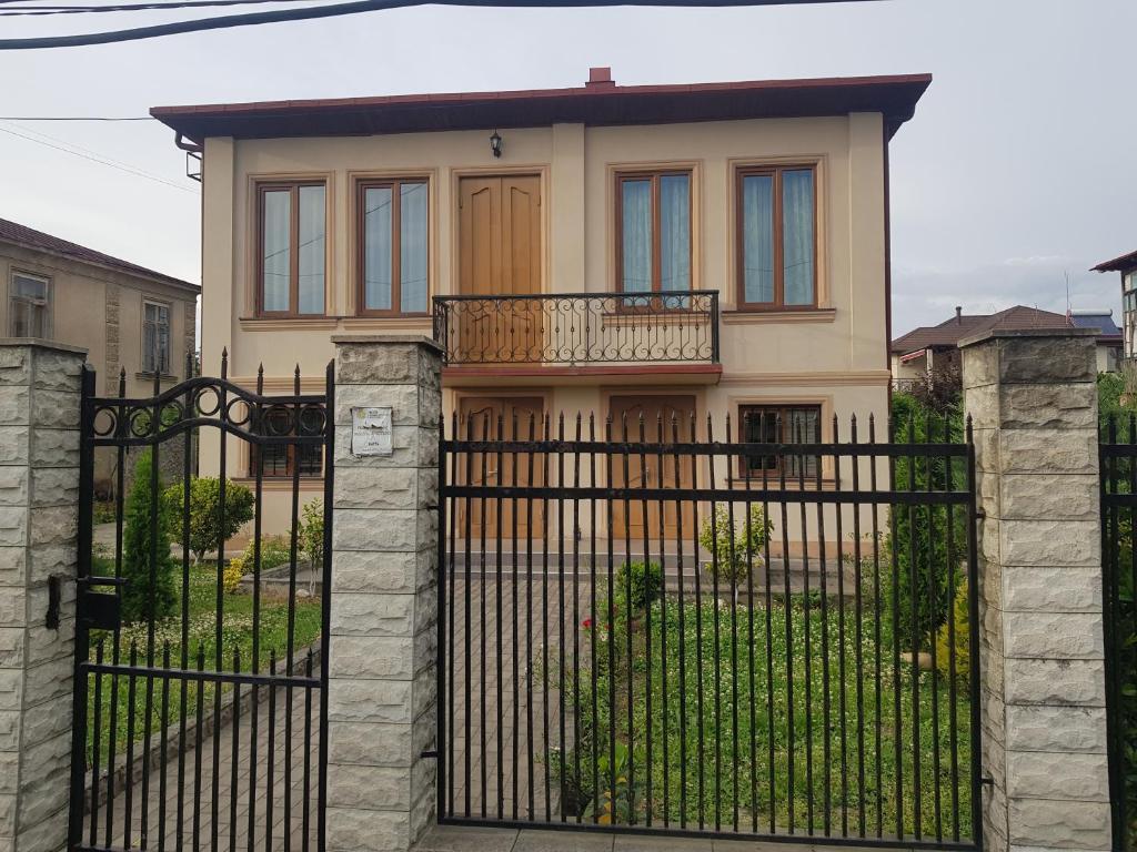uma casa com um portão preto com uma cerca em Nagi House em Zugdidi