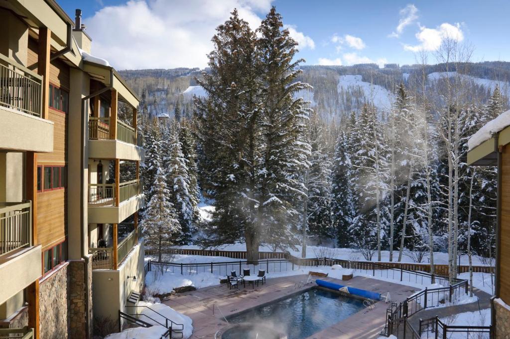 a balcony view of a pool with snow covered trees at Lodge at Lionshead in Vail