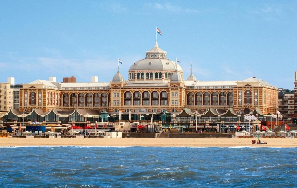 a large building on the beach in front of the water at Grand Hotel Amrâth Kurhaus The Hague Scheveningen in Scheveningen