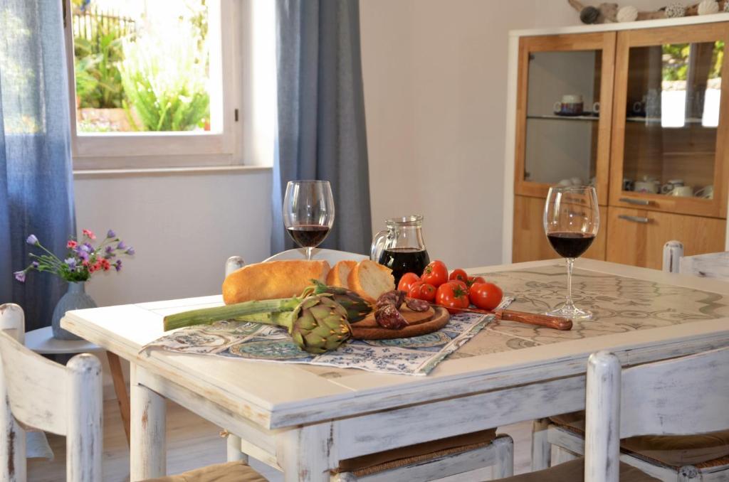een tafel met groenten en twee glazen wijn bij Home Balloon in Santa Maria Navarrese