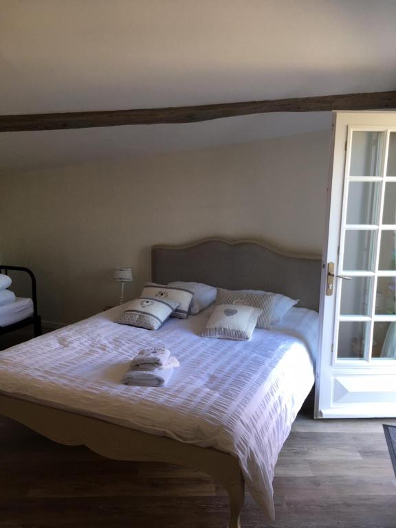 シャントネーにあるLe Gîte de Montine proche Puy du Fouのベッドルーム1室(大型ベッド1台、白いシーツ、枕付)