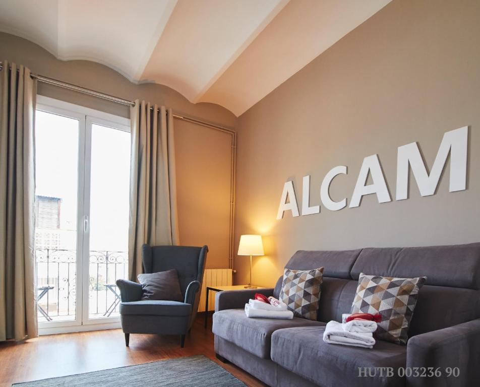 a living room with a couch and a sign on the wall at Alcam Rizal in Barcelona