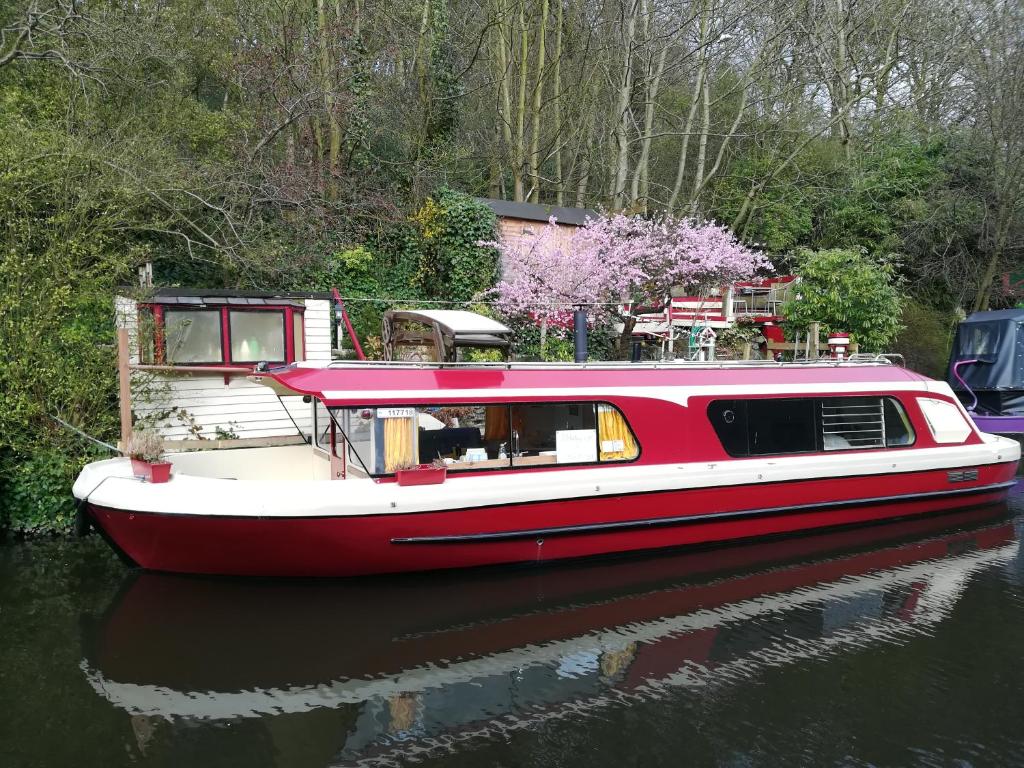 a red and white boat sitting in the water at Misty Lady in Hebden Bridge