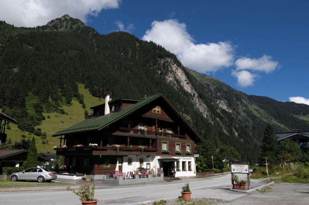 un gran edificio frente a una montaña en Hotel Gasthaus Schwarzenstein, en Ginzling