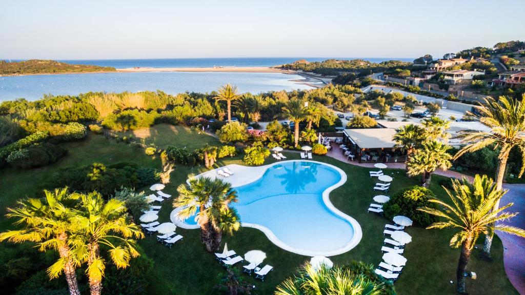 een luchtzicht op een resort met een zwembad en palmbomen bij Hotel Aquadulci in Chia