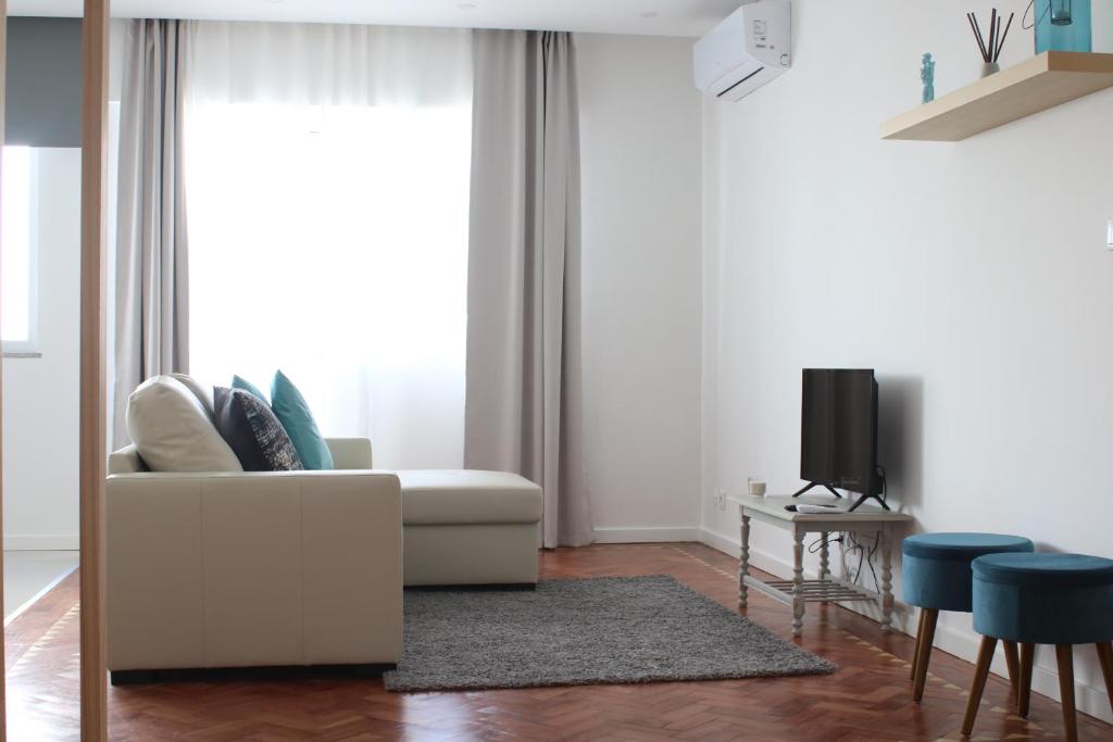 salon z białą kanapą i telewizorem w obiekcie Fátima4You w Fatimie