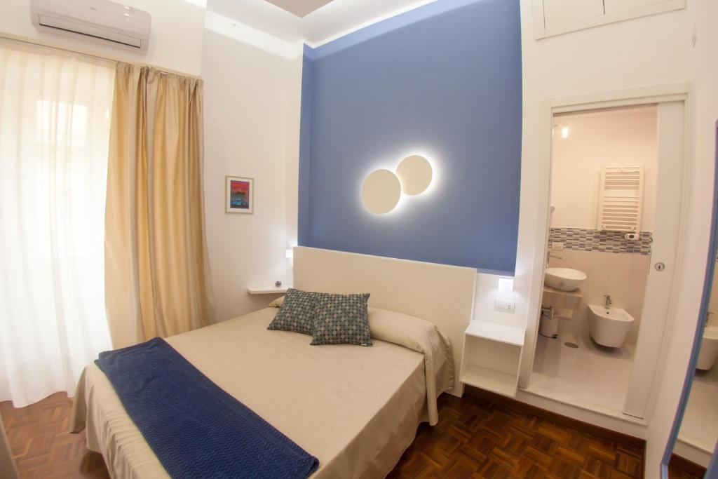 una piccola camera con letto e parete blu di 319 al Duomo a Napoli