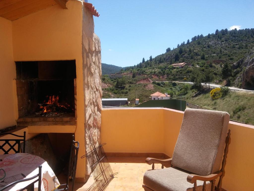 a balcony with a fireplace and a couch and chairs at Casa Serrana in Santa Cruz de Moya