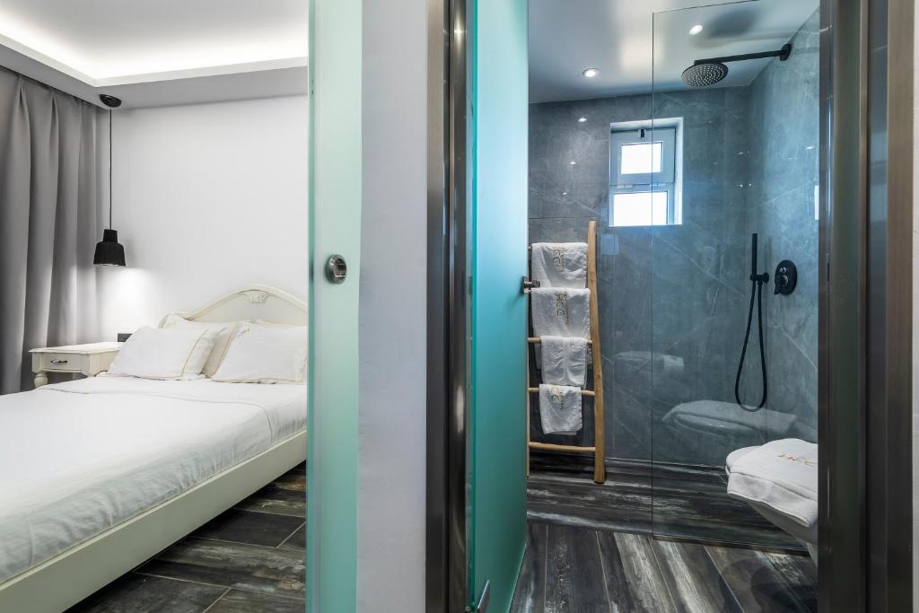a bedroom with a bed and a glass shower at Diamond Boutique Hotel in Kos