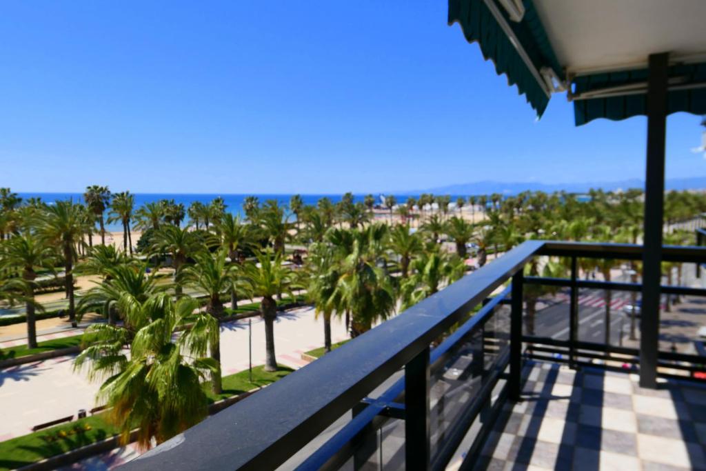 a balcony with a view of the beach and palm trees at Rentalmar family Anagabu in Salou