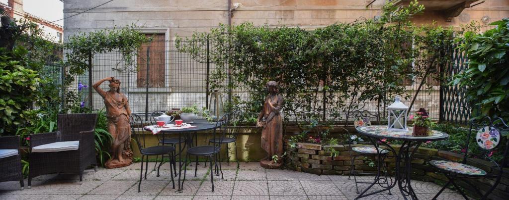 a patio with two tables and chairs and plants at Appartamento Luxury Ai Greci in Venice