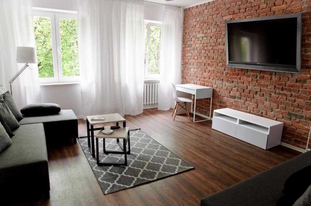 ein Wohnzimmer mit einer Ziegelwand und einem TV in der Unterkunft Kamienica Wygon Apartment in Danzig