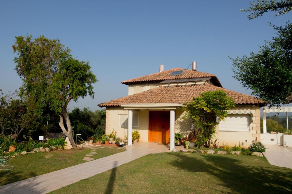 una casa blanca con garaje y patio en Bait Bagiva en Bet ‘Oved