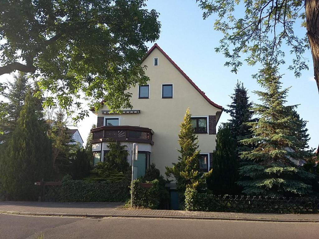 une grande maison blanche avec des arbres devant elle dans l'établissement An den Linden 31, à Leipzig
