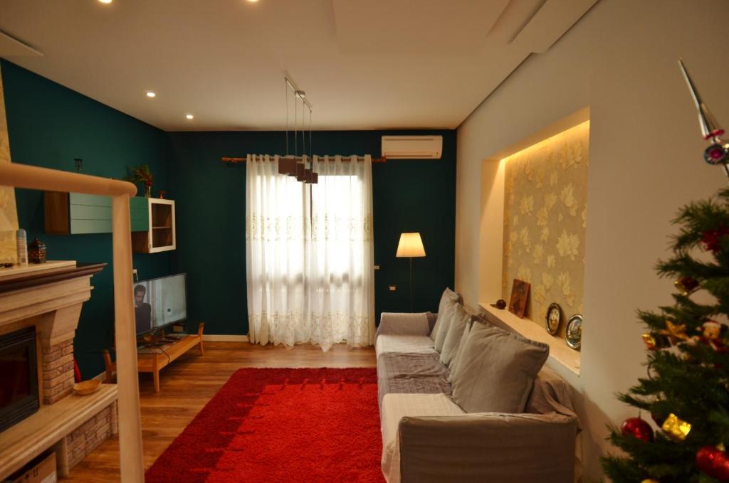 een woonkamer met een bank en een kerstboom bij Apartments Kaloj in Tirana