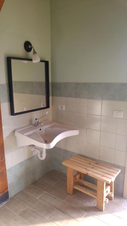 a bathroom with a sink and a bench and a mirror at Yurte in Langa in Bosia