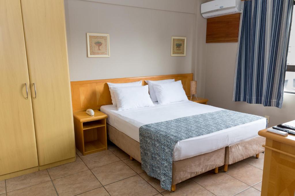 Postel nebo postele na pokoji v ubytování Maria Quitéria Hotel & Flat