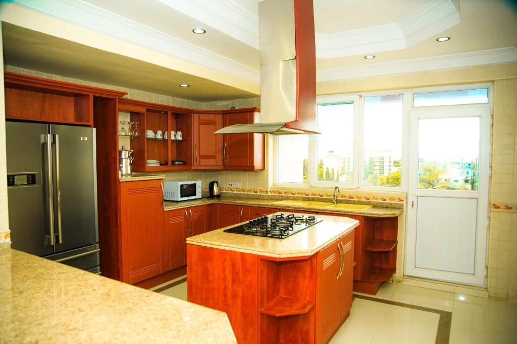 a kitchen with wooden cabinets and a stove top oven at Luxury Apartment with Ocean View in Oyster Bay in Dar es Salaam