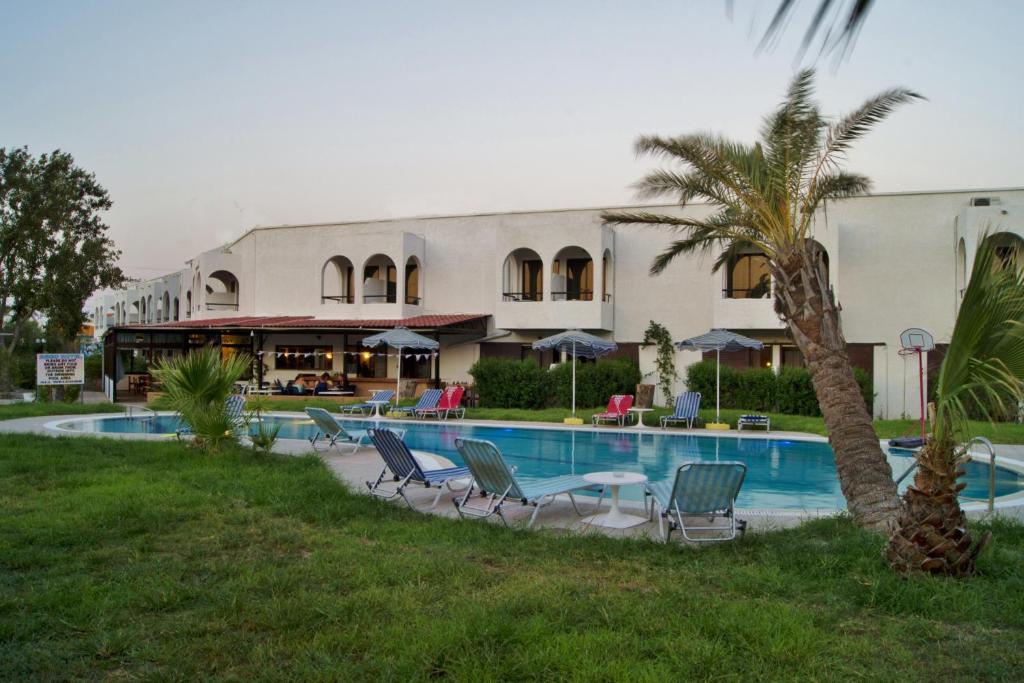 un complejo con piscina, sillas y una palmera en Argo Hotel, en Faliraki