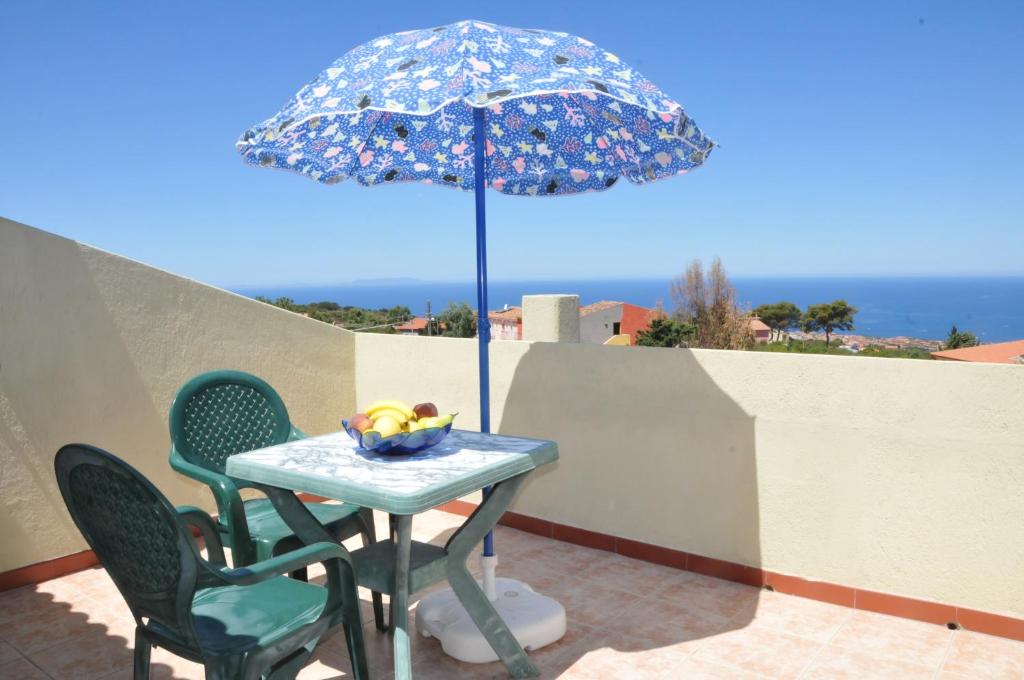 トリニタ・ダグルトゥにあるBellavista " La Contra"の青い傘と椅子2脚付きテーブル