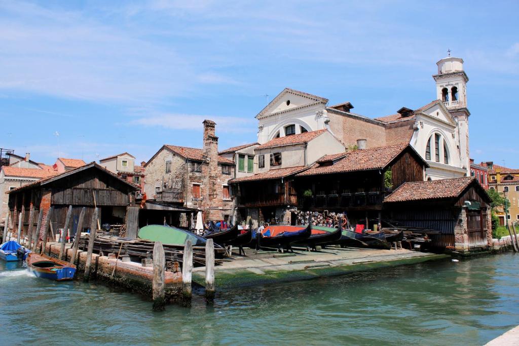 un gruppo di edifici vicino all'acqua con barche di San Gervasio Apartment a Venezia