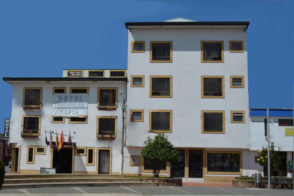 um edifício branco com um cartaz em Hotel Esmeralda Plaza em Zipaquirá