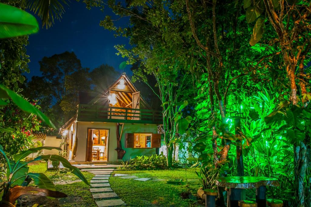 a house in the middle of a forest at night at Casa Rústica in Arraial d'Ajuda