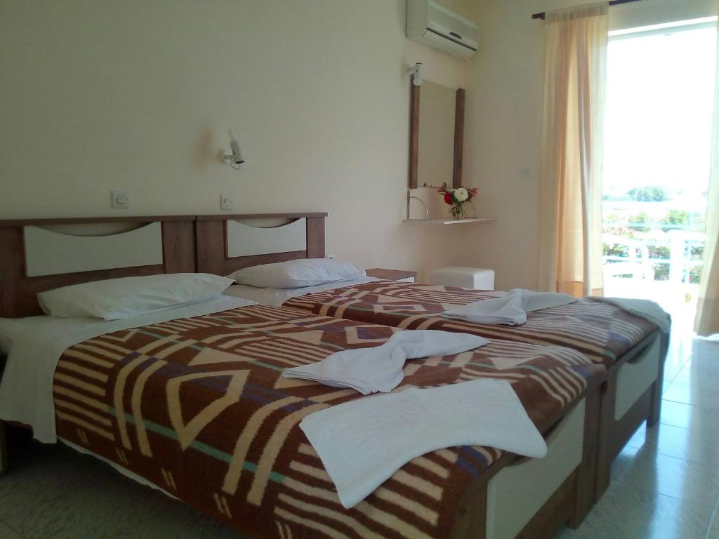 Postel nebo postele na pokoji v ubytování Leonidas Hotel & Studios